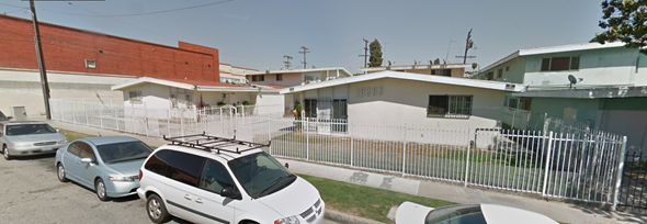 Inglewood apartment for rent - A white car is parked in front of a white building with a red roof.