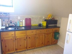 Ottawa apartment for rent - A kitchen with wooden cabinets and a black counter top.
