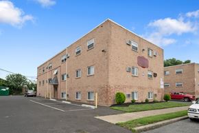 Philadelphia apartment for rent - a brick apartment building with cars parked in front of it