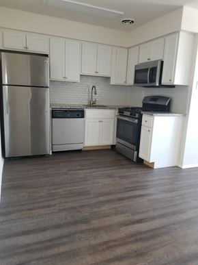 Philadelphia apartment for rent - an empty kitchen with stainless steel appliances and white cabinets