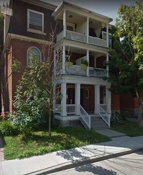 Ottawa apartment for rent - a red brick house with a white porch and stairs