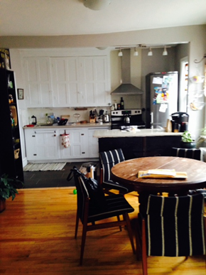 Ottawa apartment for rent - a kitchen with white cabinets and a table and chairs