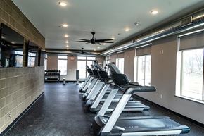 Ames apartment for rent - a gym with cardio machines and a ceiling fan