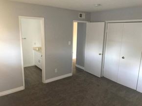 Long Beach apartment for rent - a bedroom with white closets and a carpeted floor