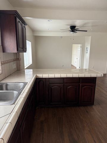 Los Angeles apartment for rent - A kitchen with dark wood cabinets and a white countertop.