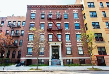 Brooklyn apartment for rent - A red brick building with a black door and windows.
