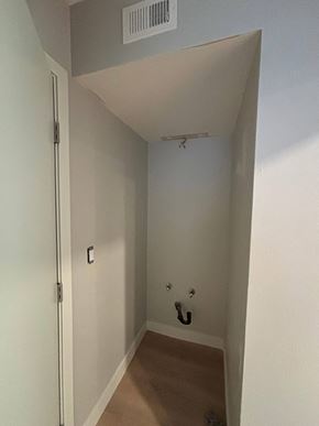 Carlsbad house for rent - A white door with a silver handle is on the left side of a hallway with a light switch and a black hook on the wall.