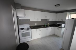 Hamilton apartment for rent - A kitchen with white cabinets and appliances.