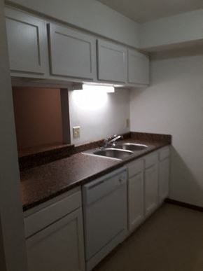 Sussex apartment for rent - A kitchen with brown countertops and white cabinets.