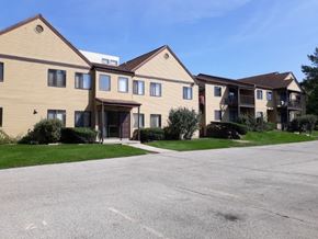 Sussex apartment for rent - A large apartment complex with a parking lot in front.
