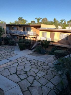 Imperial Beach apartment for rent - A courtyard with a stone floor and a building in the background.
