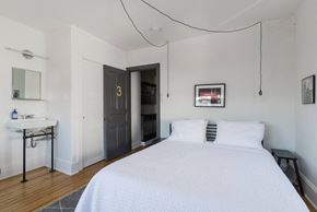 Narberth house for rent - A bedroom with a bed, sink, and mirror.