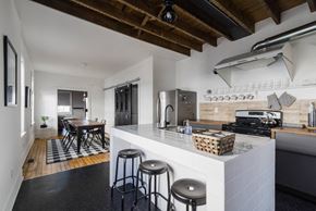 Narberth house for rent - A kitchen with a white counter and black stools.