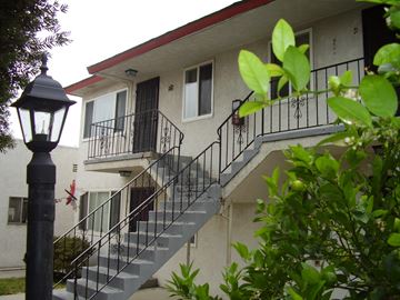 San Diego apartment for rent - A house with a red roof and a balcony with a metal railing.