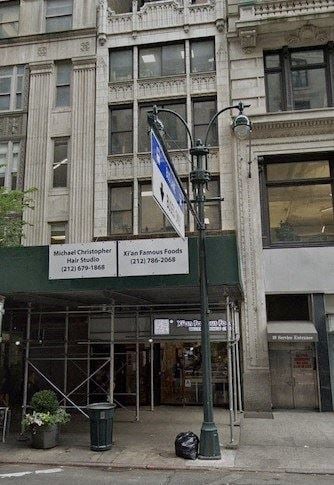 New York apartment for rent - a street sign on a pole in front of a building