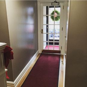 Astoria apartment for rent - a red carpeted hallway leading to a door with a wreath on it