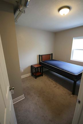 Hamilton apartment for rent - A bedroom with a bed and a small table.