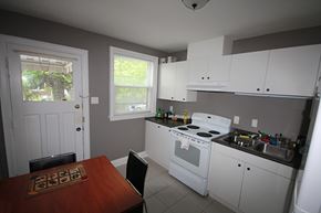 Hamilton apartment for rent - A kitchen with white appliances and a brown table.
