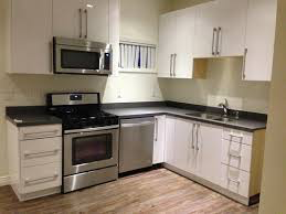 Los Angeles apartment for rent - a kitchen with white cabinets and a stove and a microwave