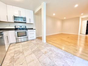 Los Angeles apartment for rent - an empty kitchen and living room with white cabinets and stainless steel appliances