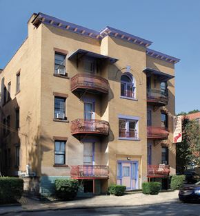 Pittsburgh apartment for rent - A tan building with a blue door and a balcony.