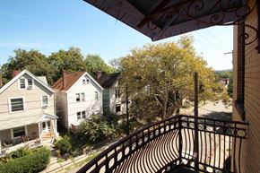 Pittsburgh apartment for rent - A balcony with a metal railing overlooks a residential street.