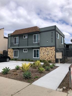 San Diego apartment for rent - A house with a grey facade and a stone wall.