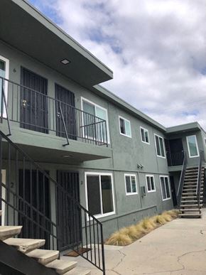 San Diego apartment for rent - A grey building with black railings and steps leading to the entrance.