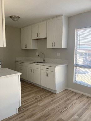 San Diego apartment for rent - an empty kitchen with white cabinets and a sink
