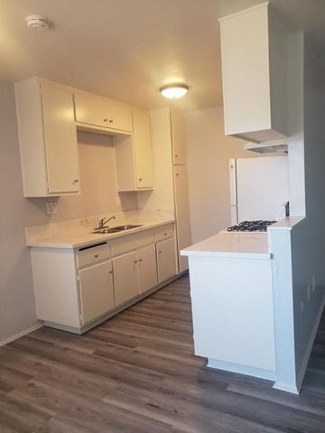 San Diego apartment for rent - a kitchen with white cabinets and a wooden floor