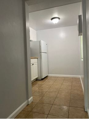 Solana Beach apartment for rent - an empty kitchen with a refrigerator and a window
