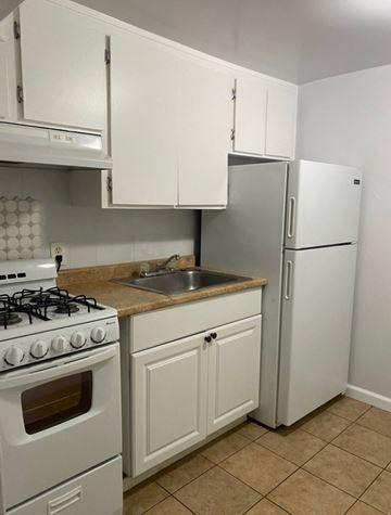 Solana Beach apartment for rent - a kitchen with white cabinets and a stove and a refrigerator