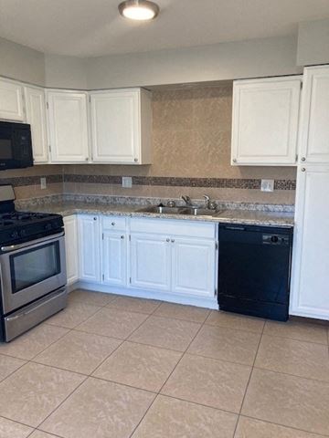 San Diego apartment for rent - a kitchen with white cabinets and a counter top
