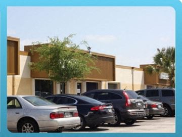 Deerfield Beach apartment for rent - A parking lot with cars and a building in the background.