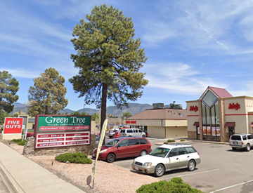Flagstaff apartment for rent - A parking lot with a sign for Green Tree and a building with a red roof.
