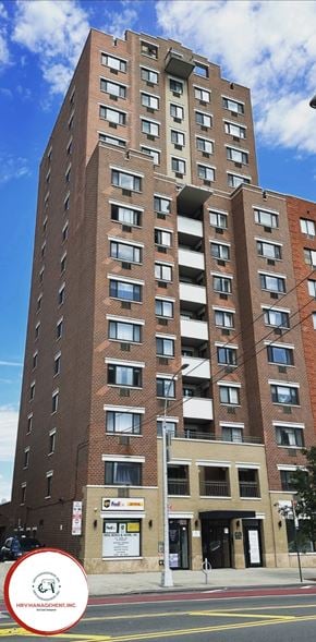 Astoria apartment for rent - A tall brick building with many windows and balconies.