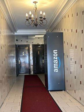 Astoria apartment for rent - A hallway with a red carpet and a wall with a brick pattern.