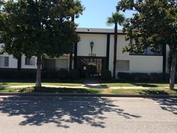 Pasadena apartment for rent - A white building with a black awning and a black lamp post.