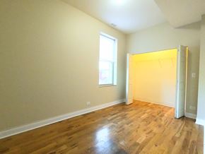 Chicago apartment for rent - A room with wooden floors and a window.