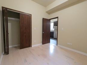 Chicago apartment for rent - A room with a wooden floor and two wooden doors.