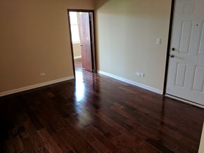 Chicago apartment for rent - A room with a wooden floor and a white door.