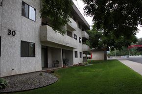 Spokane apartment for rent - a view of the side of a building with grass and trees