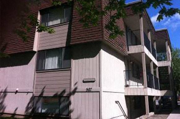 Spokane apartment for rent - a white and brown apartment building on a street