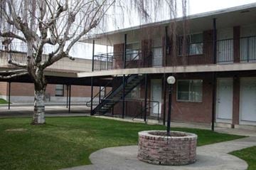 Spokane apartment for rent - an apartment building with a courtyard and a tree