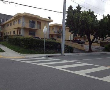 Miami apartment for rent - A crosswalk is in front of a yellow building.