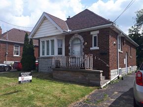 Hamilton apartment for rent - a small brick house with a porch and a street sign in front of it