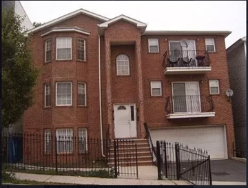 Newark apartment for rent - A red brick house with a white door and black iron fence.