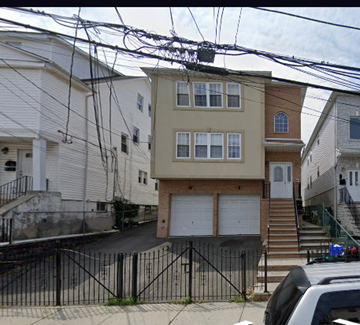 Newark apartment for rent - A two-story house with a garage is in front of a white house.
