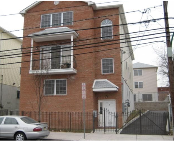Newark apartment for rent - A red brick building with a white door and a sign on the wall.