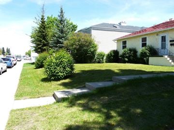 Calgary house for rent - a house with a lawn and a sidewalk in front of it